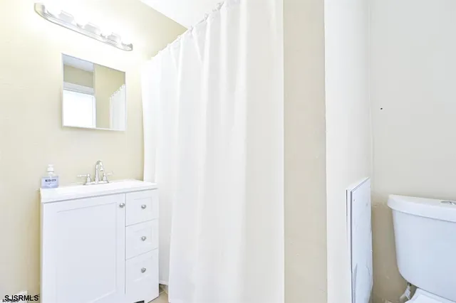 a bathroom with a sink a toilet and a mirror