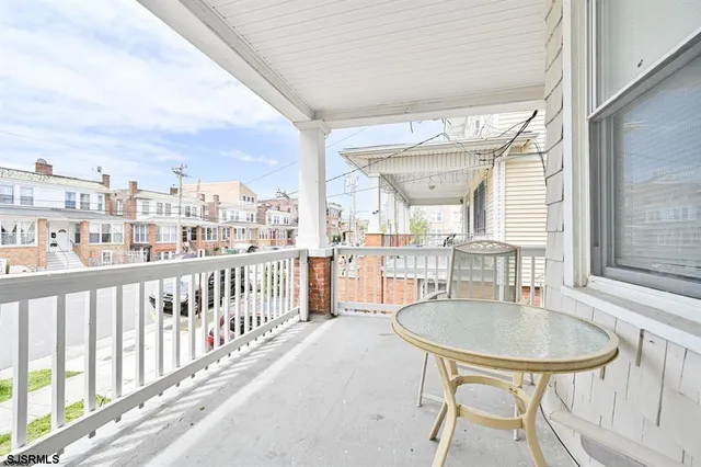 a balcony with table and chairs