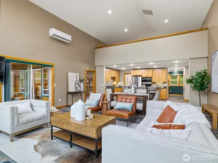 a living room with furniture kitchen view and large windows
