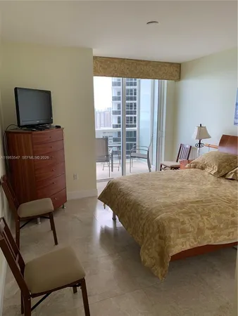 a bedroom with a bed and large windows