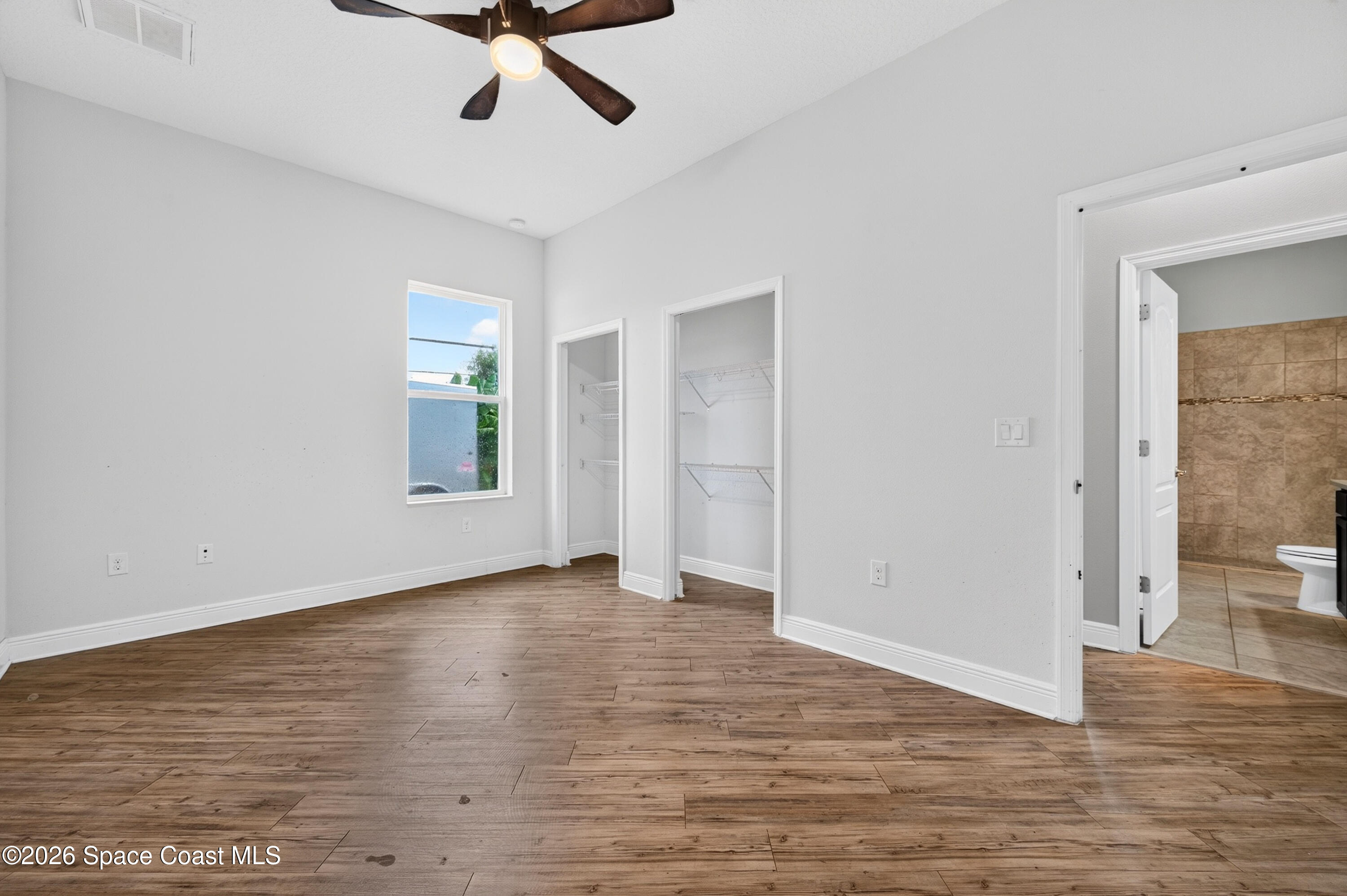 1475 Dalbora Road Merritt Island, FL 32953 - Photo 46 of 57 an empty room with wooden floor and windows