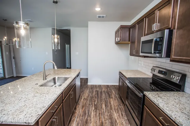 a bathroom with a granite countertop sink toilet and mirror