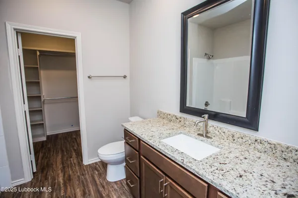 a large bedroom with kitchen island granite countertop wooden floor granite counter tops and white cabinets