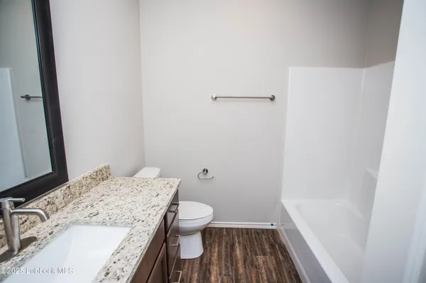 an empty room with wooden floor chandelier fan and closet