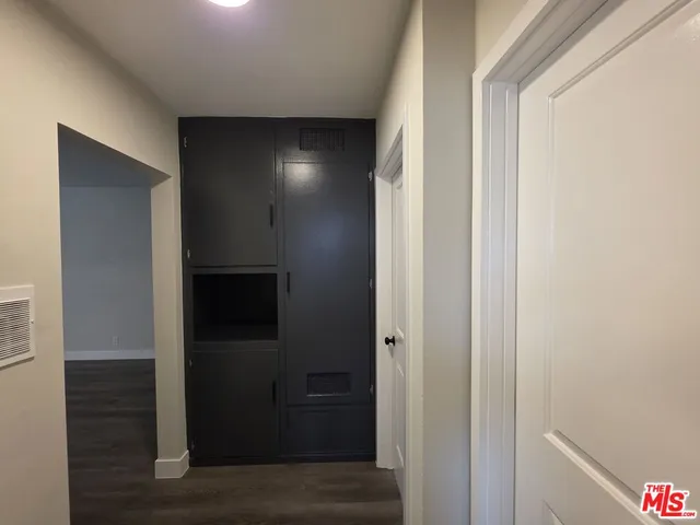 a view of an empty room and wooden floor and a window