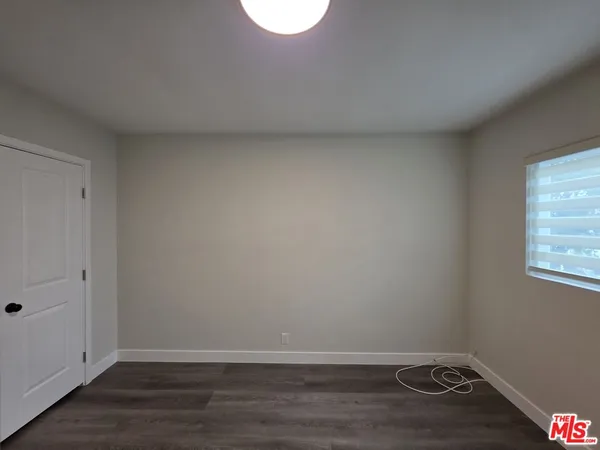 a view of a room with wooden floor and white walls