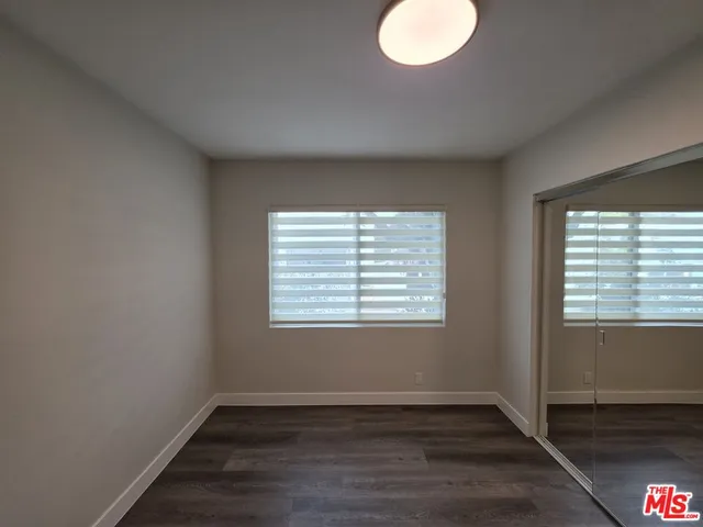 an empty room with wooden floor and sliding door