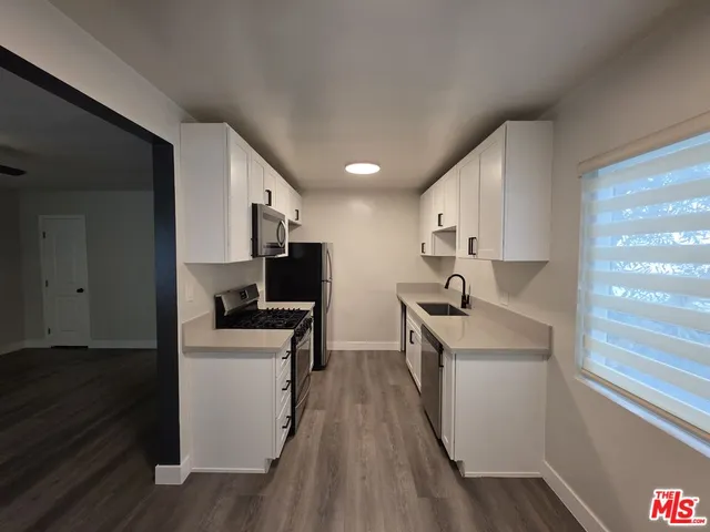 a kitchen with stainless steel appliances a sink a stove and microwave