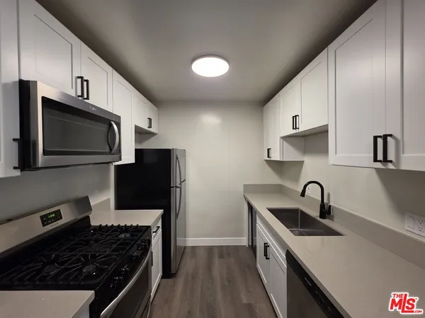 a kitchen with stainless steel appliances a refrigerator stove and microwave