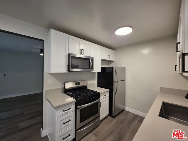 a kitchen with stainless steel appliances a sink a stove and a refrigerator