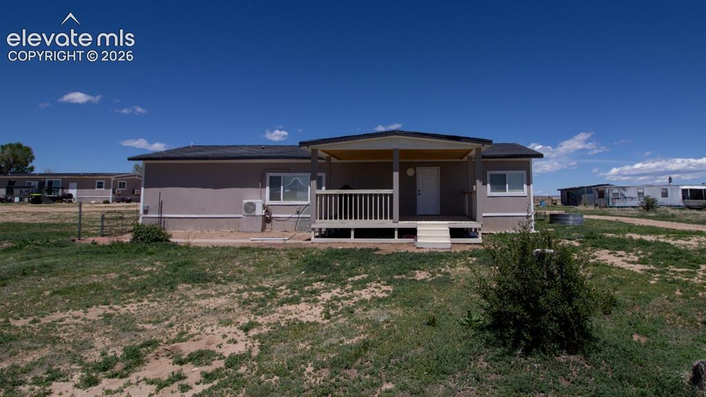 3425-3435 Wiesner Road Calhan, CO 80808 - Photo 16 of 25 Back of house with a lawn and a cooling unit