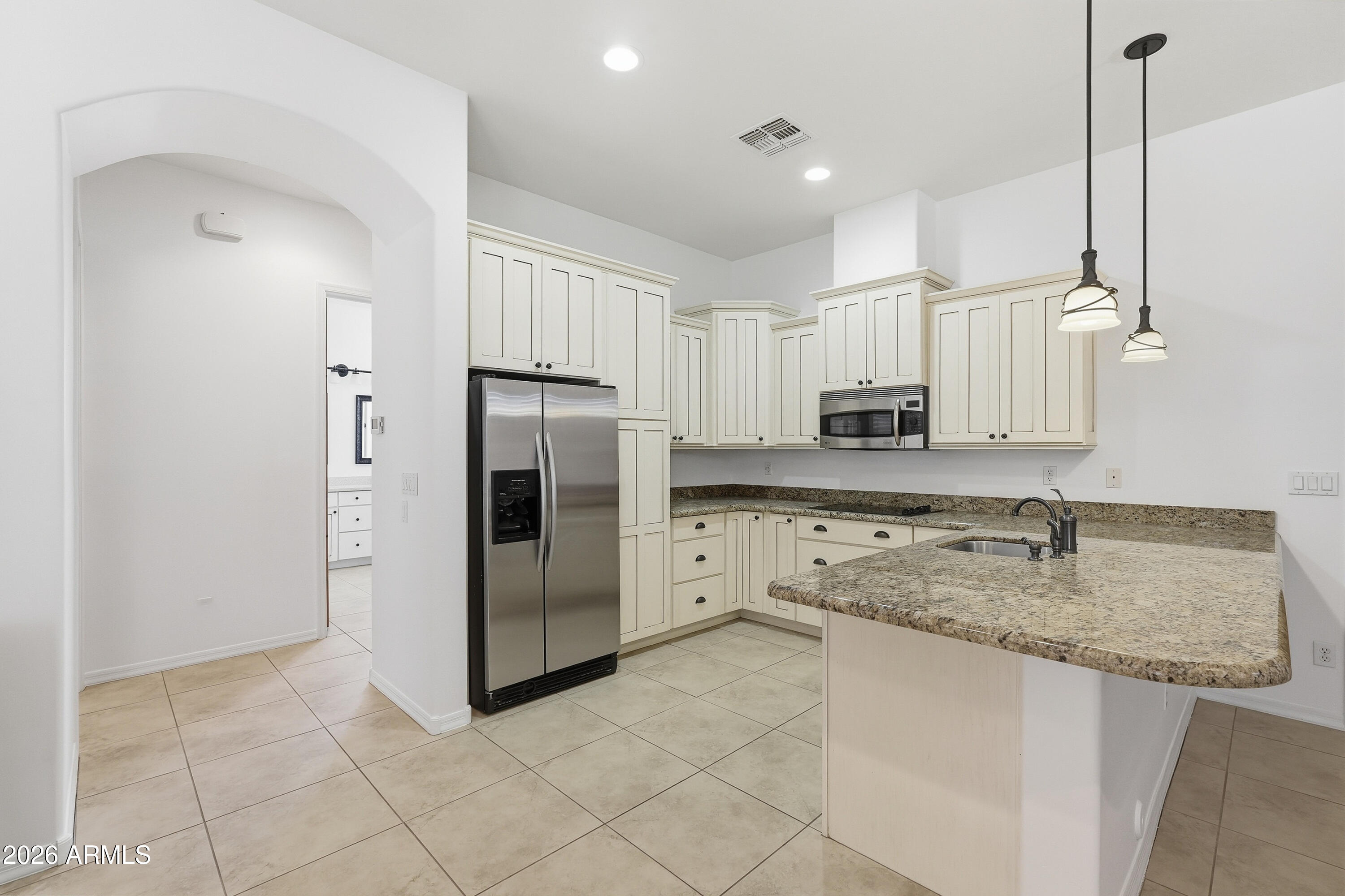 2616 West Canyon Road Phoenix, AZ 85086 - Photo 34 of 45 a kitchen with kitchen island granite countertop cabinets and stainless steel appliances