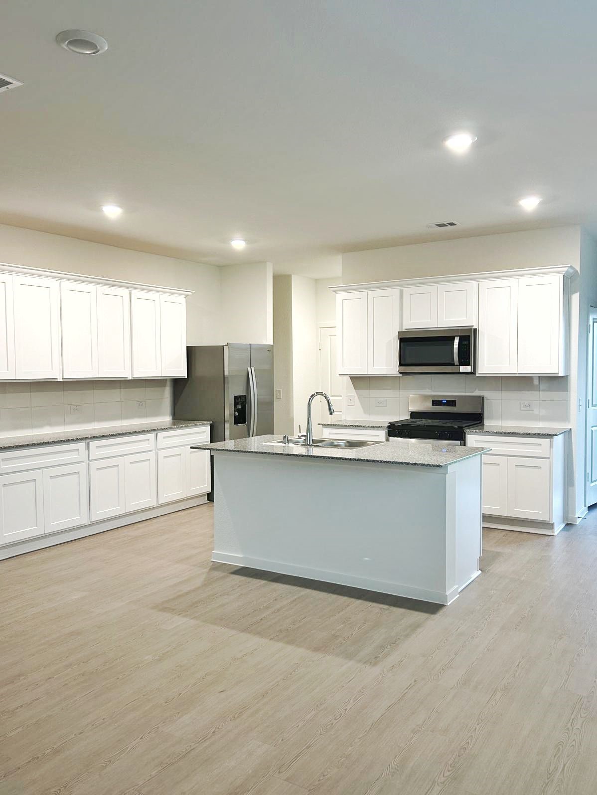 14973 Rustic Moon Road Conroe, TX 77302 - Photo 4 of 22 a kitchen with stainless steel appliances granite countertop a stove a sink and a refrigerator