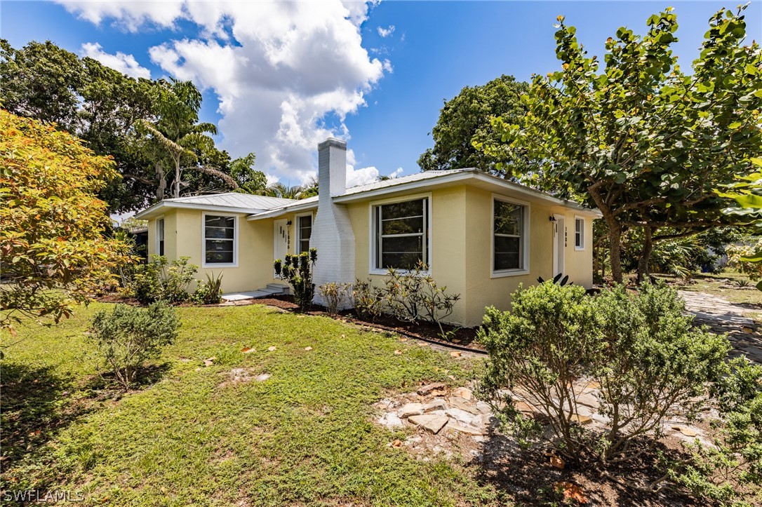 1806 Coronado Road Fort Myers, FL 33901 - Photo 1 of 23 a view of a yard in front of a house with plants and large tree