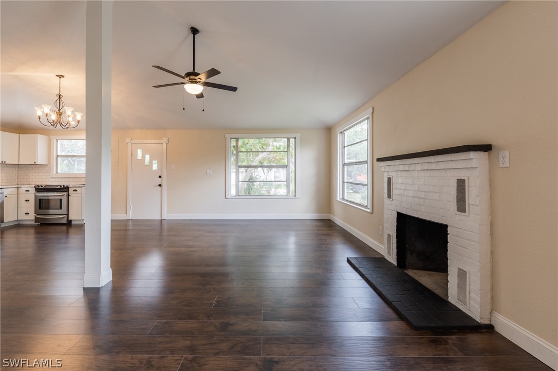 1806 Coronado Road Fort Myers, FL 33901 - Photo 4 of 23 a view of a livingroom with wooden floor a fireplace and windows