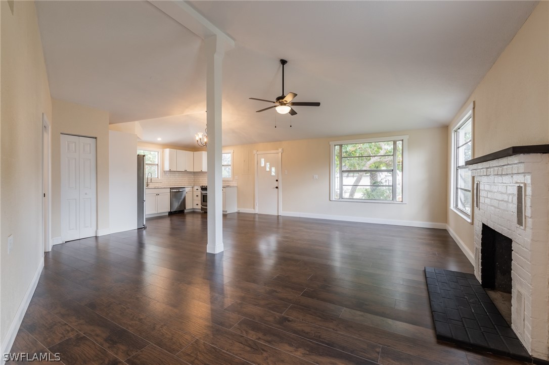 1806 Coronado Road Fort Myers, FL 33901 - Photo 5 of 23 an empty room with wooden floor fireplace and windows