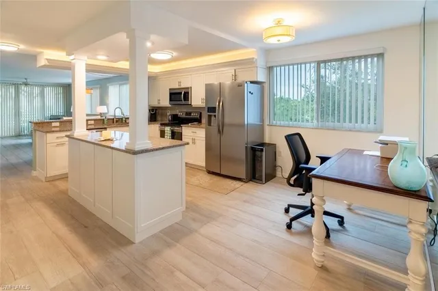 a view of a kitchen with refrigerator and dining table