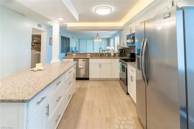 a kitchen with granite countertop a sink appliances cabinets and counter space
