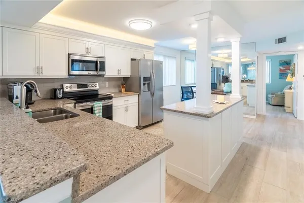 a large kitchen with stainless steel appliances granite countertop a sink stove and refrigerator