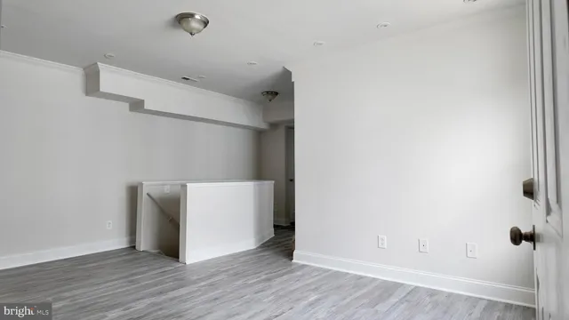 an empty room with wooden floor and white walls