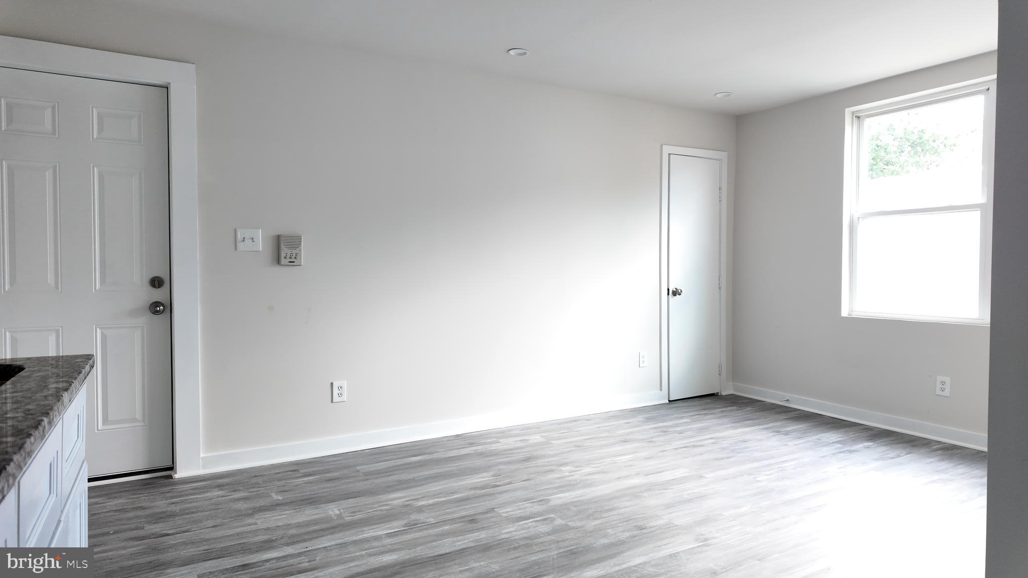 4306 Halley Terrace Southeast, Unit 1 Washington, DC 20032 - Photo 2 of 9 an empty room with wooden floor and windows