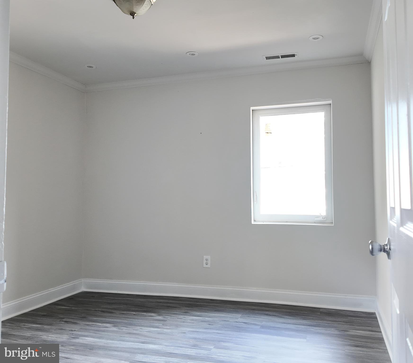 4306 Halley Terrace Southeast, Unit 1 Washington, DC 20032 - Photo 6 of 9 an empty room with wooden floor and windows