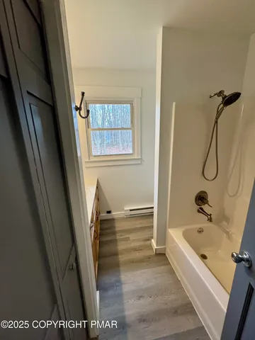 a bathroom with a tub a sink and a shower