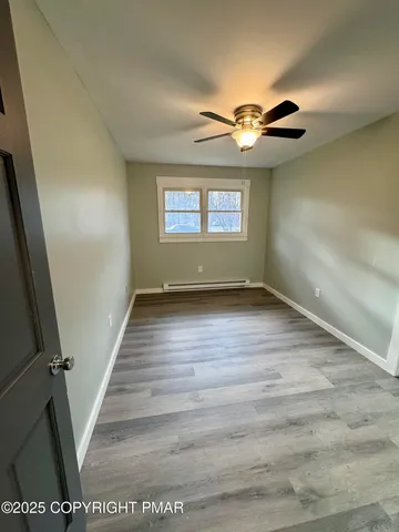 a view of empty room with wooden floor