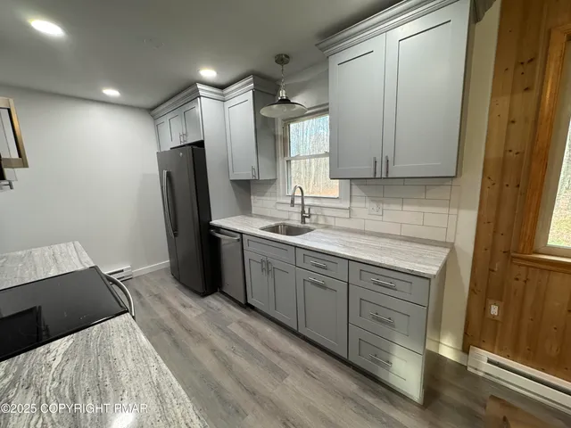 a kitchen with a refrigerator sink and cabinets