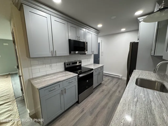 a kitchen with stainless steel appliances a stove sink microwave and cabinets