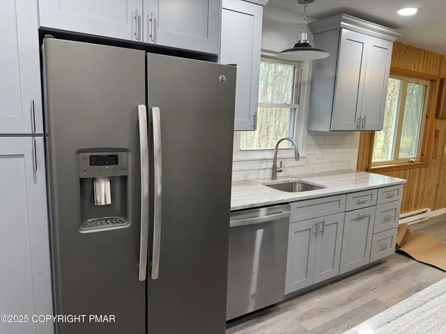 a kitchen with stainless steel appliances granite countertop a refrigerator and a sink
