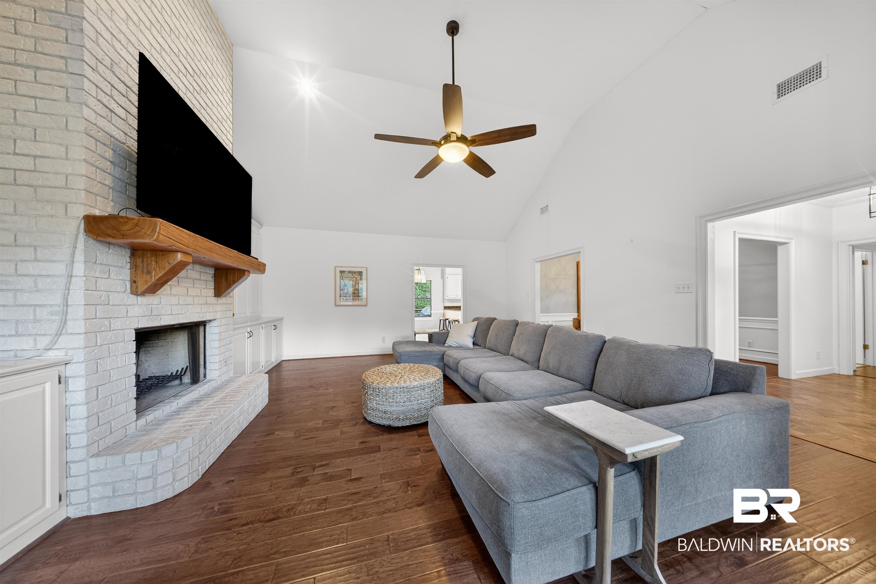 1250 Savannah Drive Mobile, AL 36609 - Photo 9 of 35 Living area featuring dark wood-type flooring, a brick fireplace, vaulted ceiling, and ceiling fan