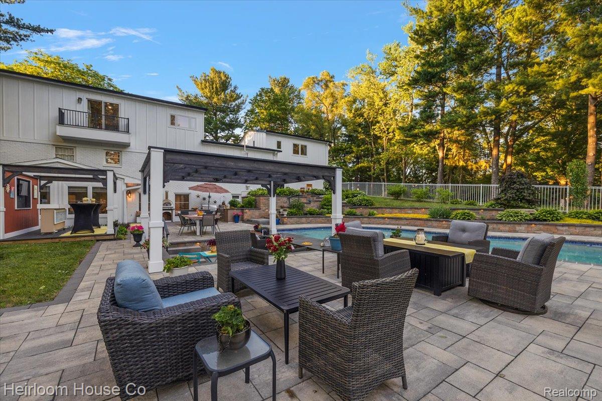 49001 Hanford Road Canton, MI 48187 - Photo 89 of 98 Spacious paver patio featuring a swimming pool, a dark wood pergola, and a separate dining area with stone steps