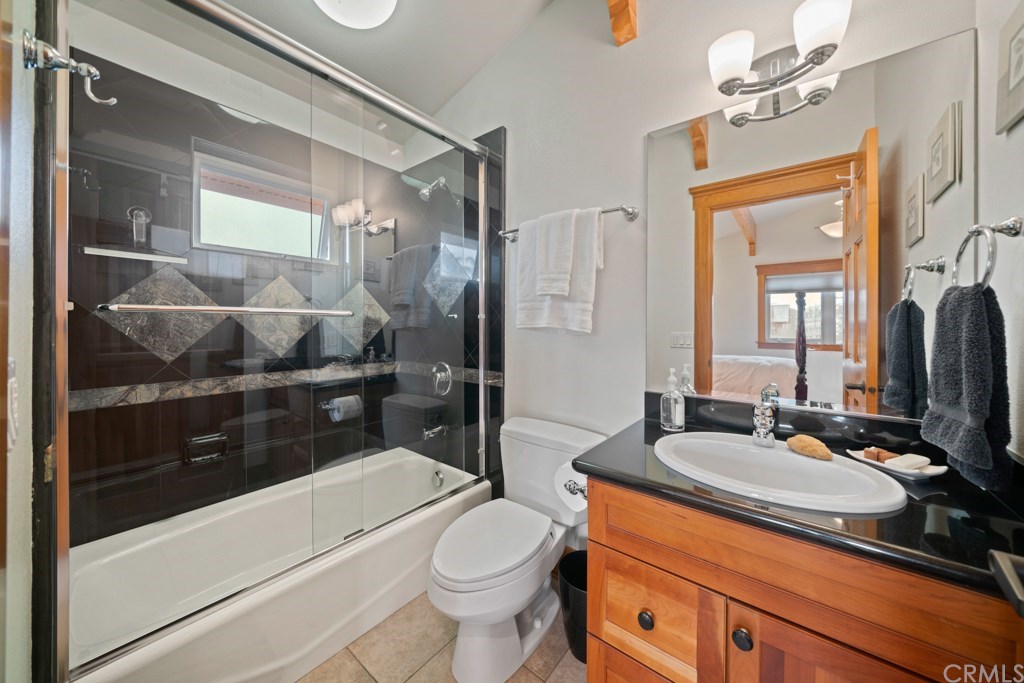 218 14th Street Seal Beach, CA 90740 - Photo 17 of 44 On-suite bathroom with black Granite and rainforest marble countertop and shower surround with solid cherry cabinets