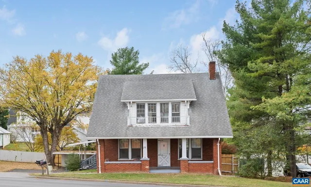 a view of a livingroom with a fireplace wooden floor and windows