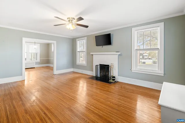 a view of an empty room with window and wooden floor