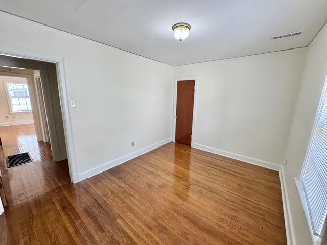 a view of an empty room with wooden floor