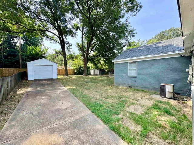 a backyard of a house with table and chairs
