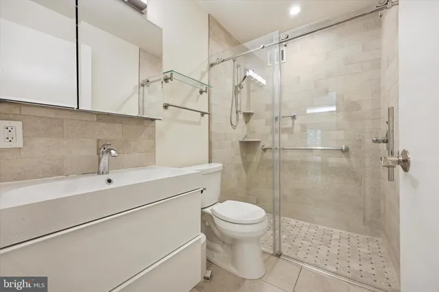a bathroom with a shower sink vanity and toilet