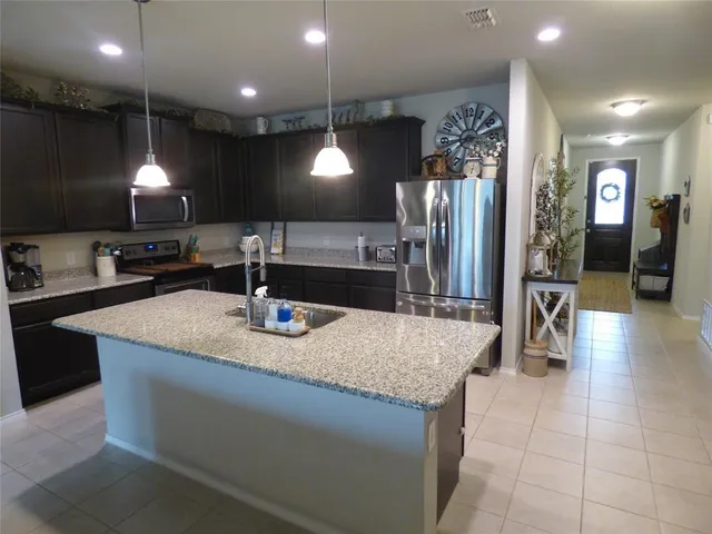 a kitchen with kitchen island a sink and a refrigerator