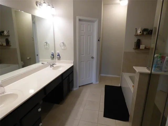 a en suite bathroom with a double vanity sink and a mirror