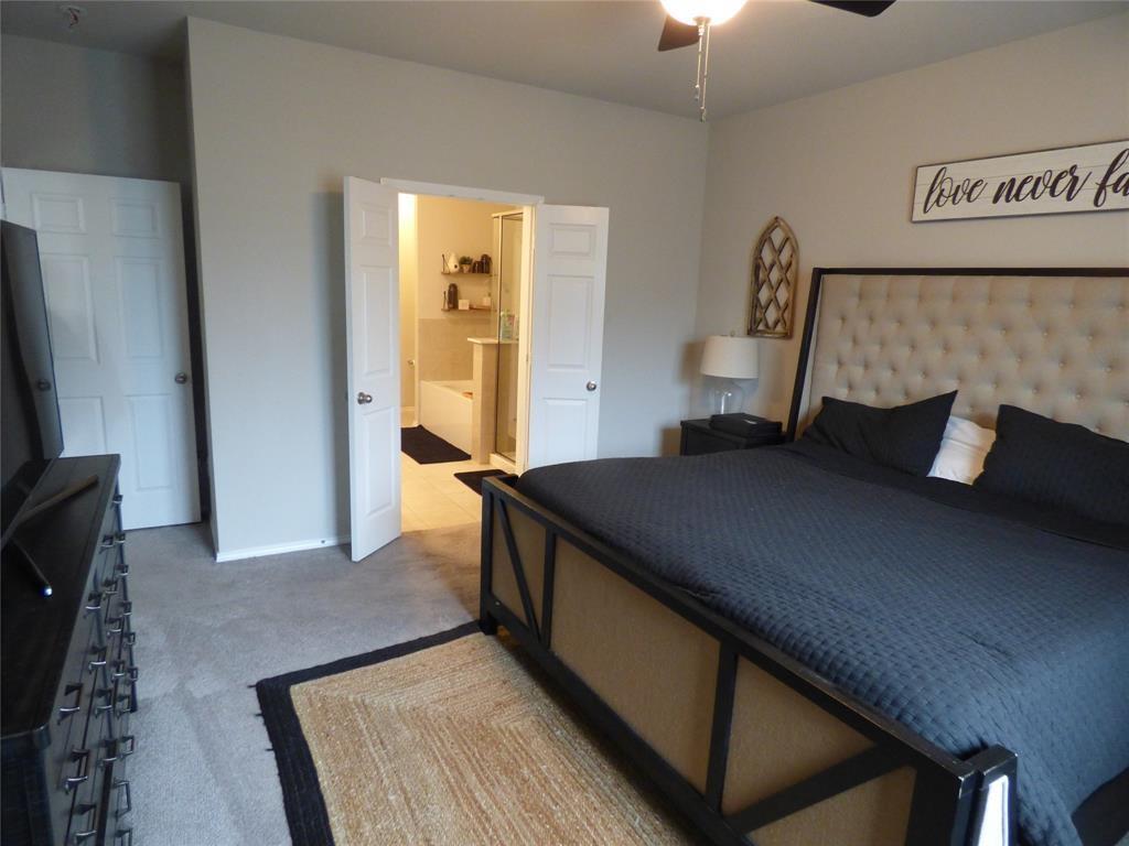 7416 Boat Wind Road Fort Worth, TX 76179 - Photo 4 of 18 a bedroom with a bed and a flat tv screen on a dresser