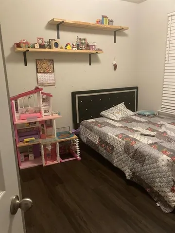 a bed sitting in a bedroom next to a window with a book shelf