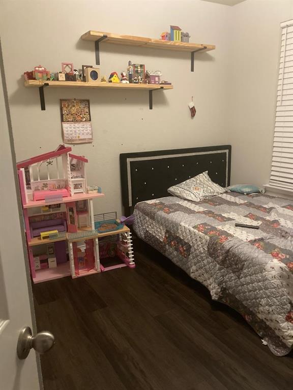 7416 Boat Wind Road Fort Worth, TX 76179 - Photo 5 of 18 a bed sitting in a bedroom next to a window with a book shelf