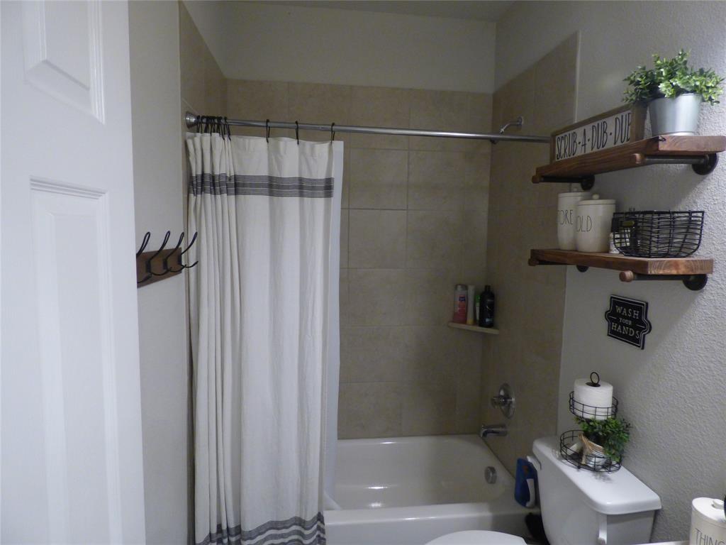 7416 Boat Wind Road Fort Worth, TX 76179 - Photo 9 of 18 a bathroom with a shower curtain and a sink
