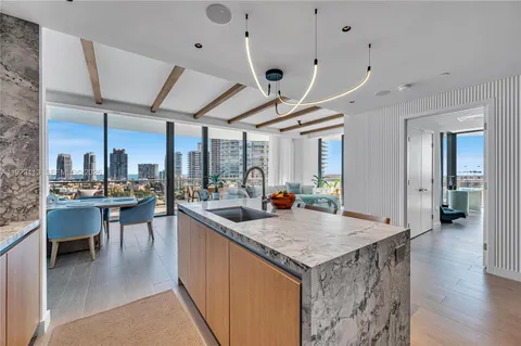 a living room with furniture a large window and stainless steel appliances