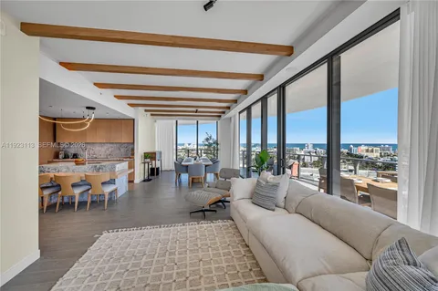 a living room with furniture a large window and stainless steel appliances