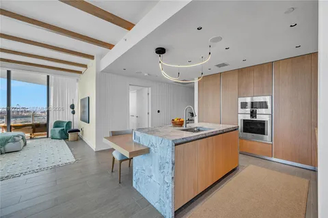 a kitchen with stainless steel appliances granite countertop a lot of cabinets and wooden floor