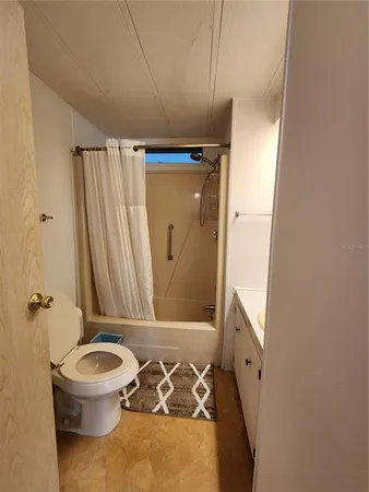 a bathroom with a granite countertop sink toilet and mirror