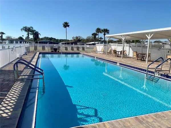 a view of a swimming pool with a table and chairs under an umbrella